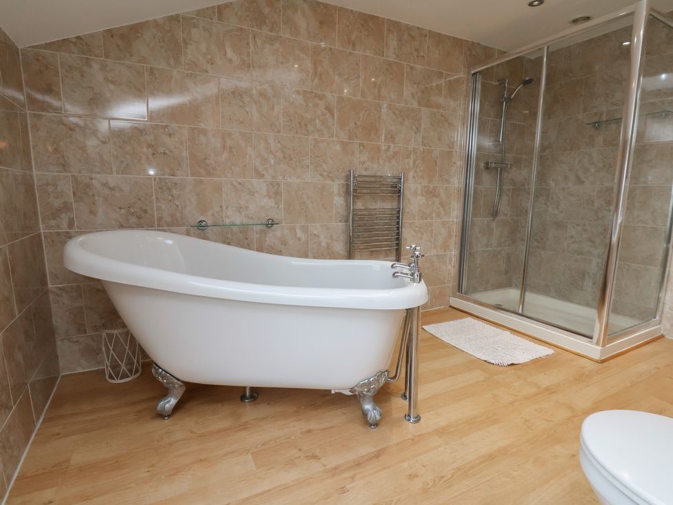 A bathroom with a bathtub and shower at Manor Farmhouse Reighton near Filey