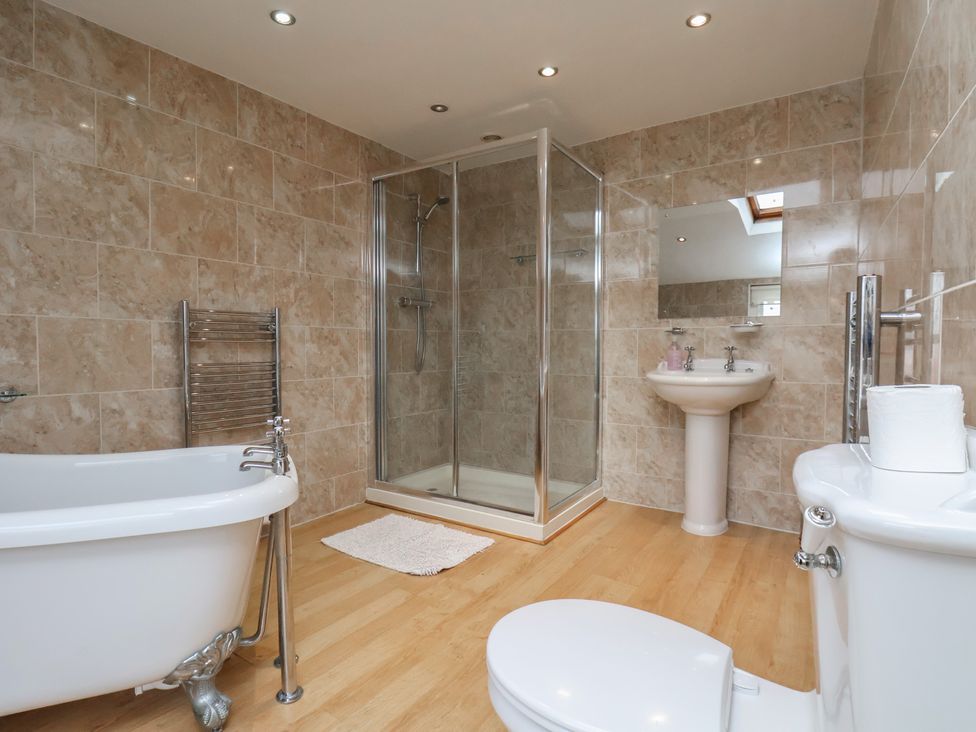 A bathroom with a bathtub, shower, sink, and toilet at Manor Farmhouse in Reighton near Filey