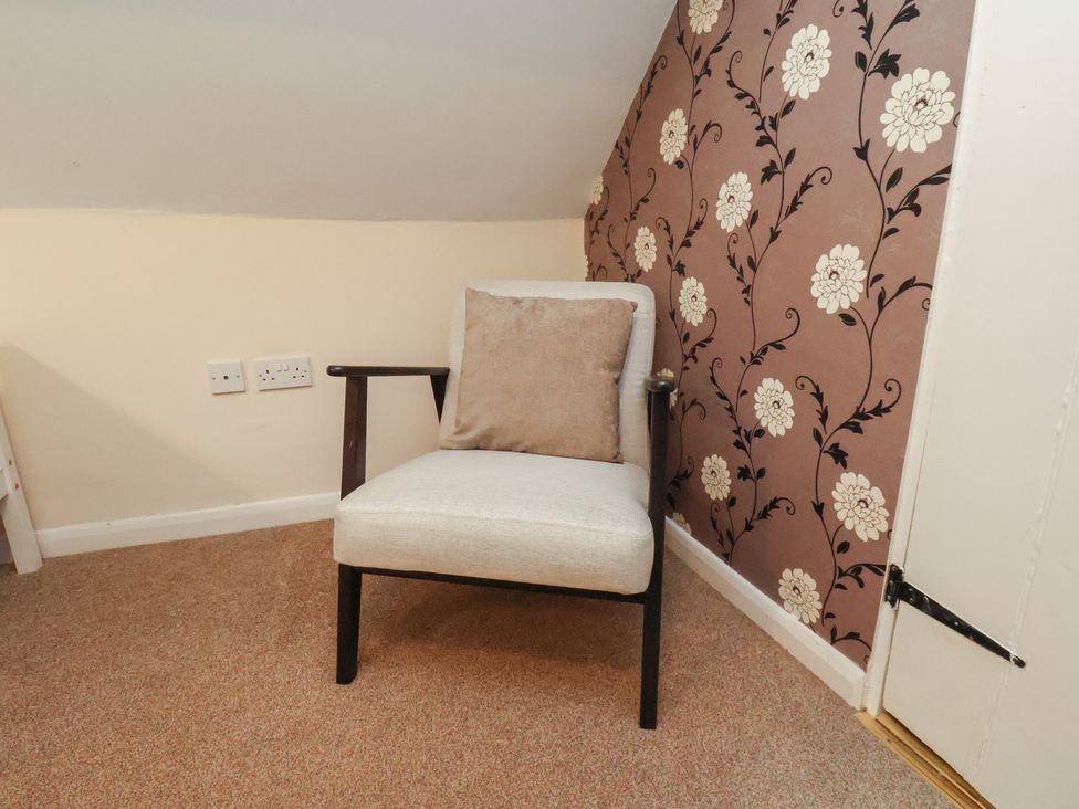 A chair against a floral wallpaper at Manor Farmhouse in Reighton near Filey