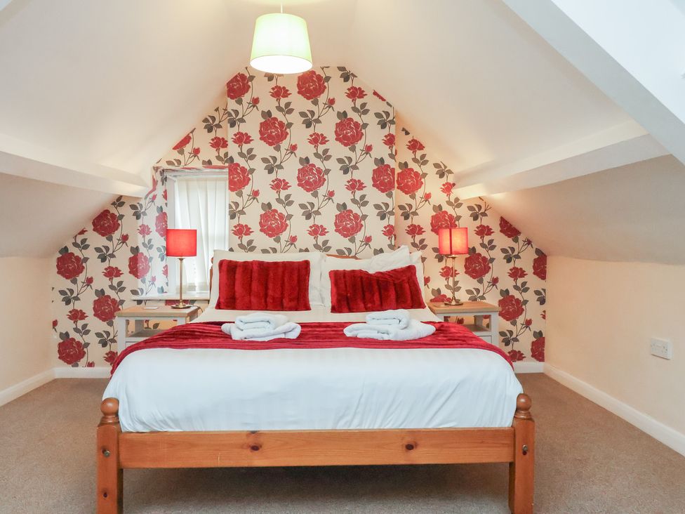 A bedroom with a bed and side tables at Manor Farmhouse in Reighton near Filey