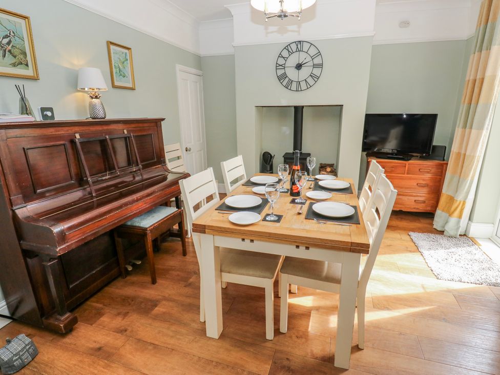 A dining room with a piano and a table set at 49 Waddington Road Clitheroe