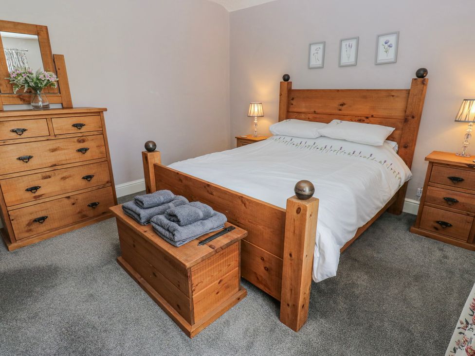 A bedroom with a bed and wooden furniture at 49 Waddington Road Clitheroe