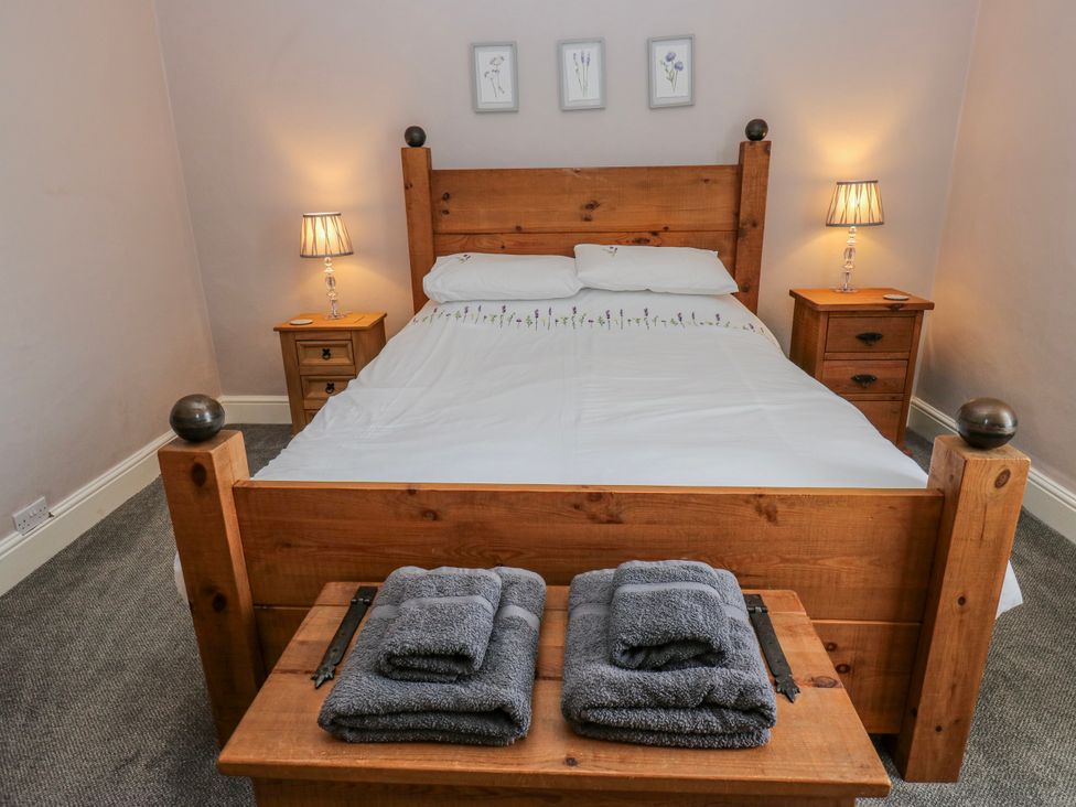 A bedroom with a wooden bed and nightstands at 49 Waddington Road Clitheroe