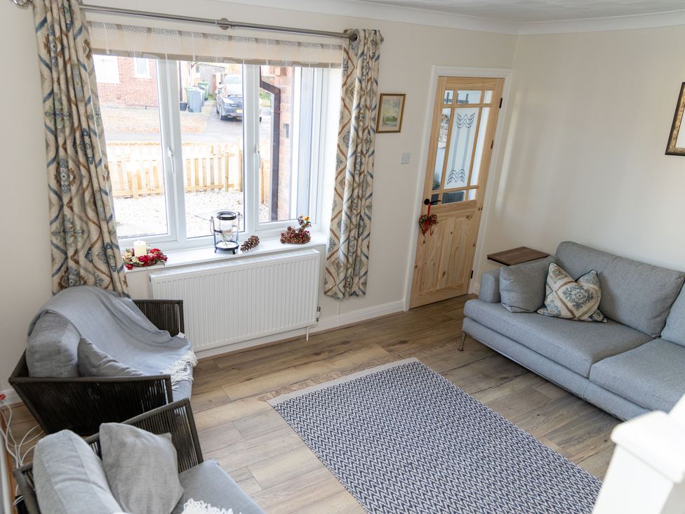 A living room with a sofa and an armchair at Deer Hill Grove in York