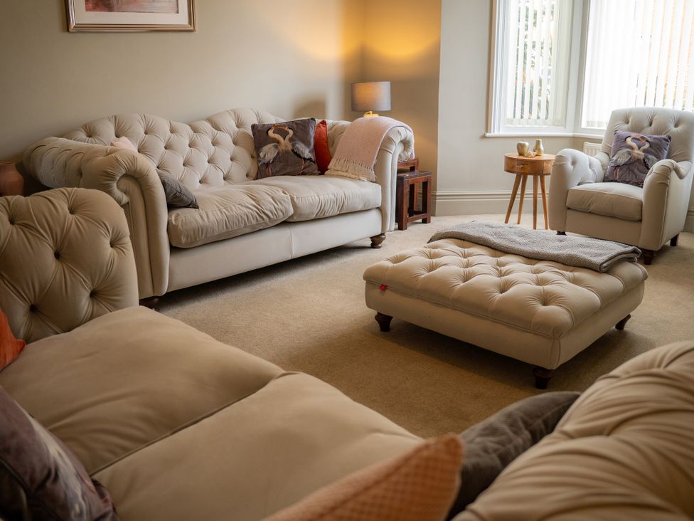 A living room with sofas and an armchair at The George in Whitley Bay