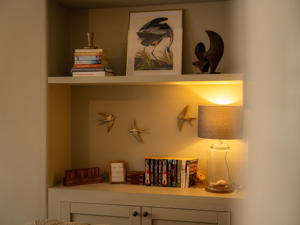 A living room with books and decorative objects on a shelf at The George in Whitley Bay