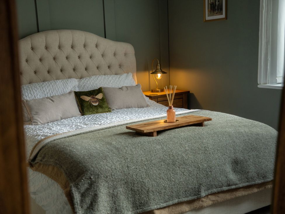 A bedroom with a bed and wooden table at The George in Whitley Bay