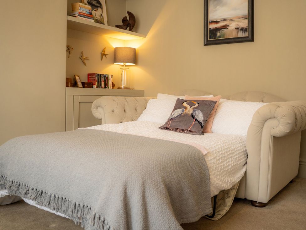 A bedroom with a bed and books on the shelf at The George in Whitley Bay