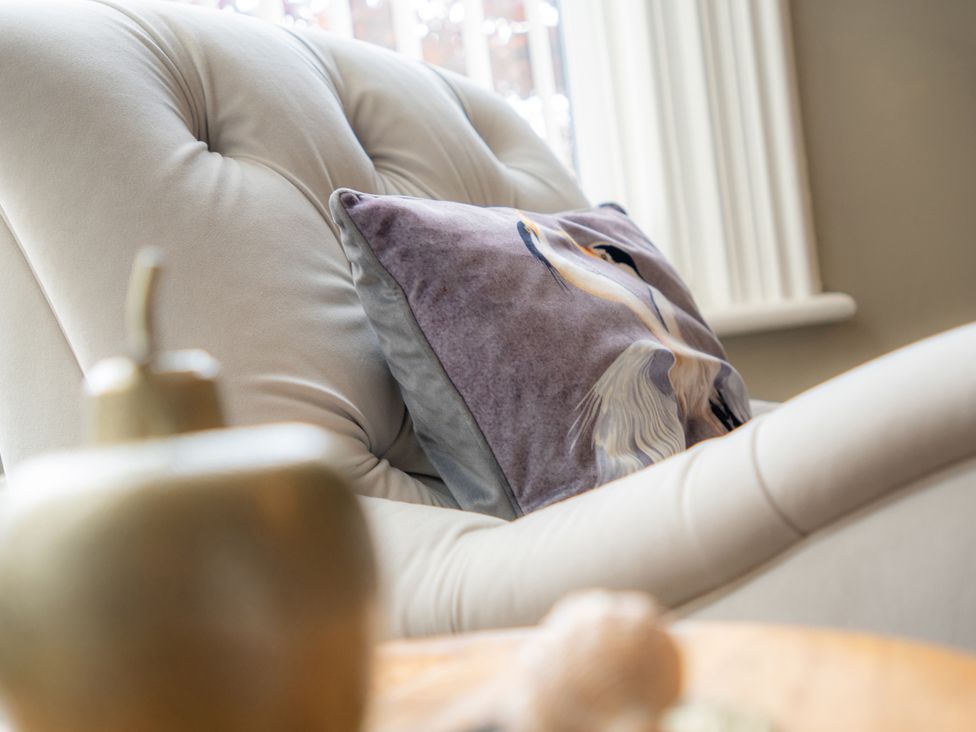 A living room with an armchair and a cushion at The George in Whitley Bay