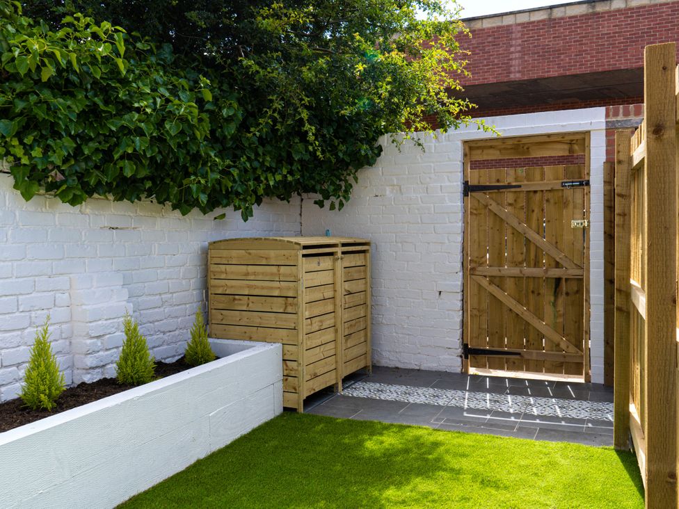A garden with storage bins and a gate at The George in Whitley Bay