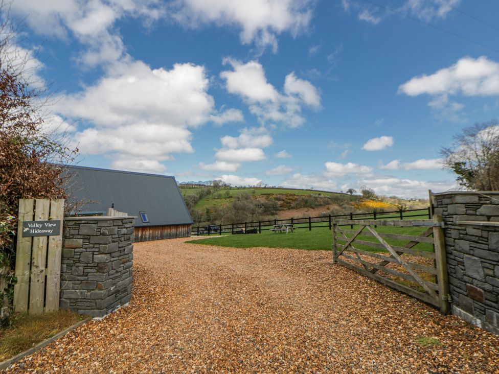 An outdoor view of a property entrance with a gravel driveway at Valley View Hideaway in Ffostrasol