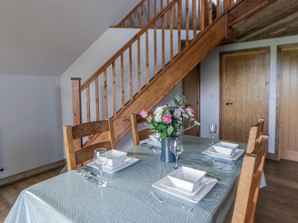 A dining room with a table set for four at Valley View Hideaway in Ffostrasol