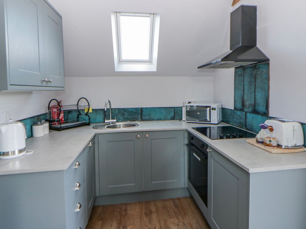 A kitchen with cabinets, sink, and appliances at Valley View Hideaway in Ffostrasol