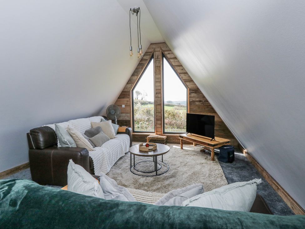 A living room with a coffee table and television at Valley View Hideaway in Ffostrasol
