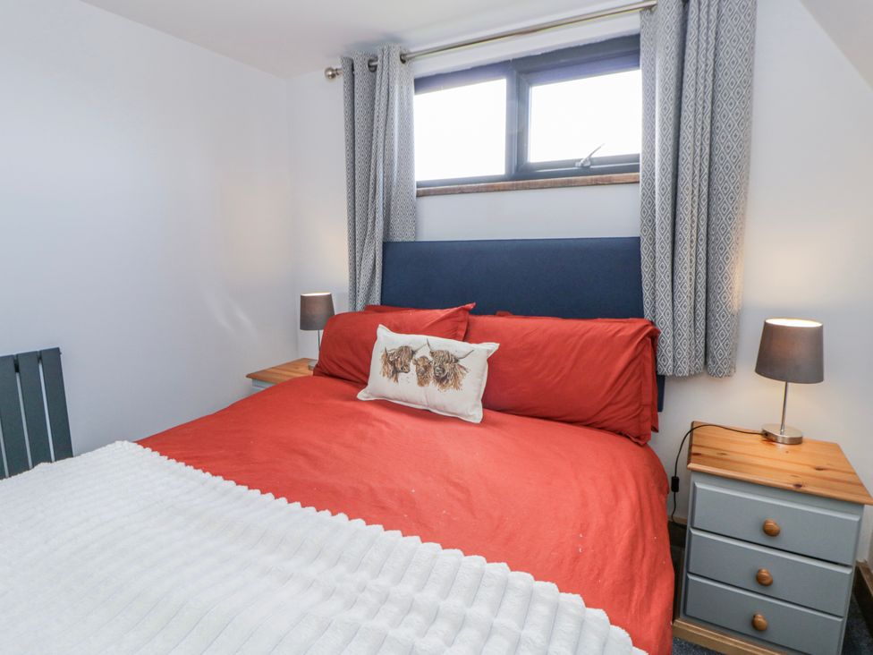 A bedroom with a bed and nightstands at Valley View Hideaway in Ffostrasol