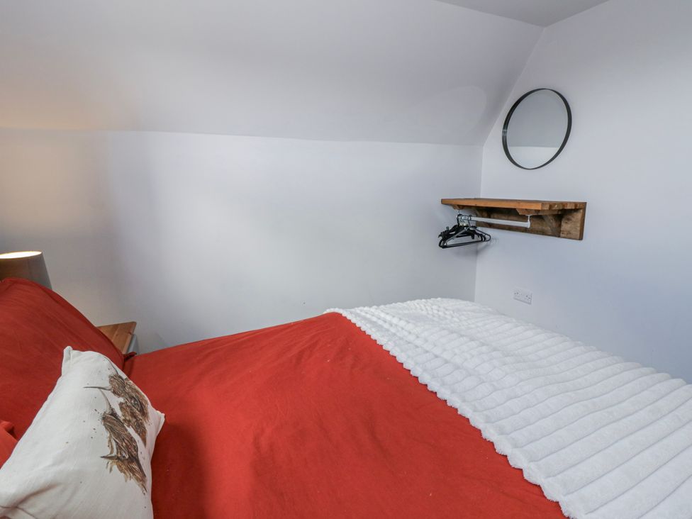 A bedroom with a bed and a shelf at Valley View Hideaway in Ffostrasol