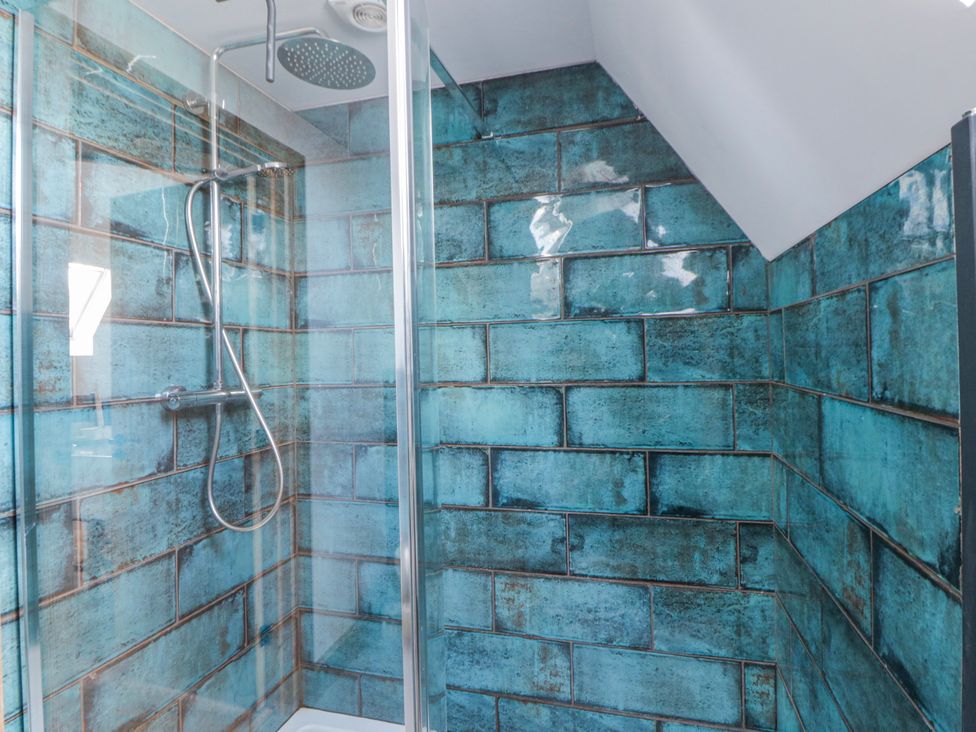 A shower with tiled walls at Valley View Hideaway Ffostrasol
