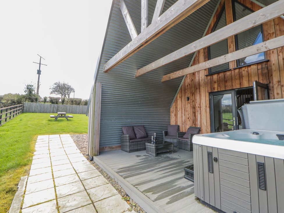 An outdoor area with seating and a hot tub at Valley View Hideaway in Ffostrasol