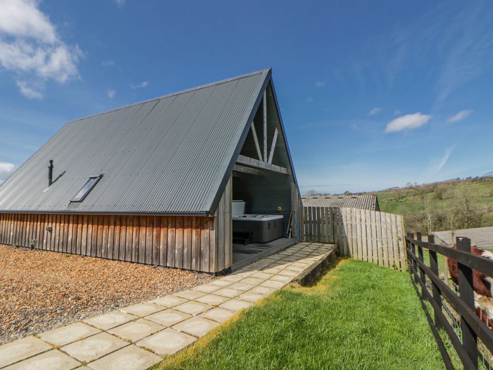 A modern building with a pathway and grass at Valley View Hideaway Ffostrasol