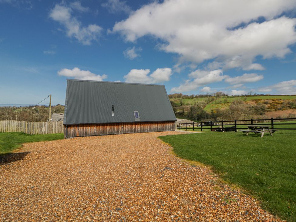 A building with a gravel path and grass at Valley View Hideaway Ffostrasol