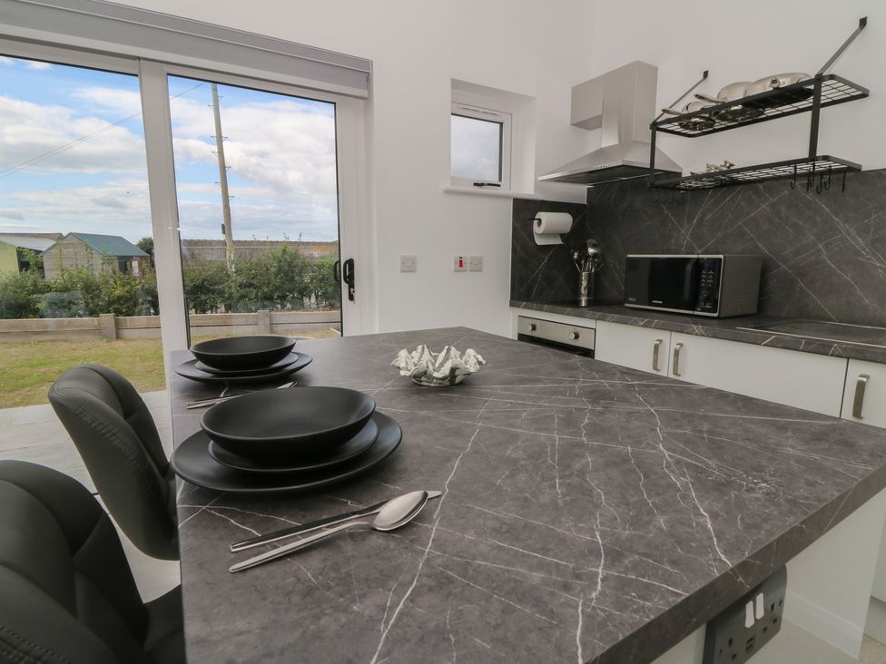 A kitchen with a dining table and kitchen appliances at Rydlan in Aberystwyth