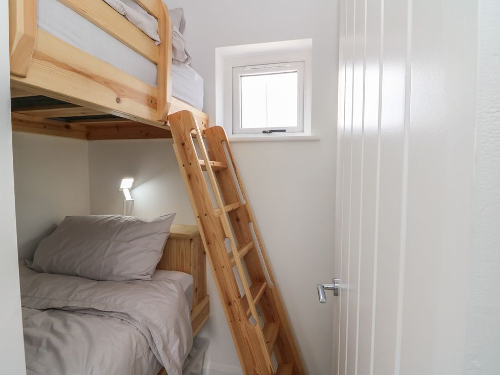 A bedroom with a bunk bed and ladder at Rydlan Aberystwyth