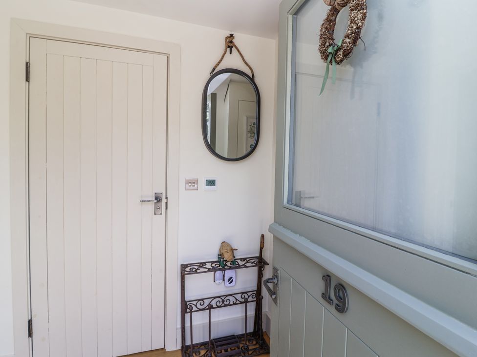 An entryway with a mirror and table at The Little Loft in Burford