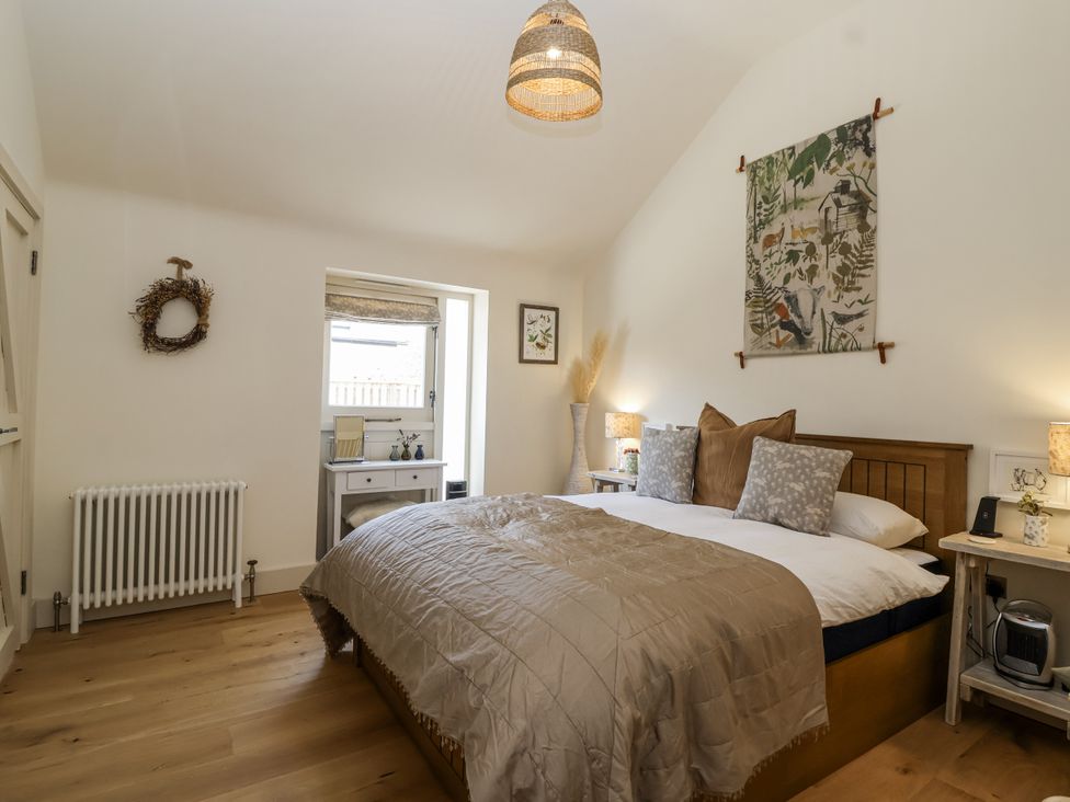 A bedroom with a bed and bedside tables at The Little Loft in Burford