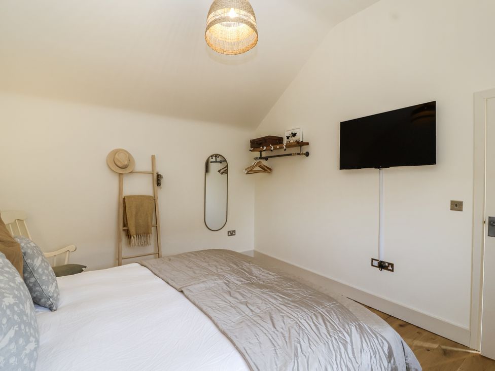 A bedroom with a bed and TV at The Little Loft in Burford