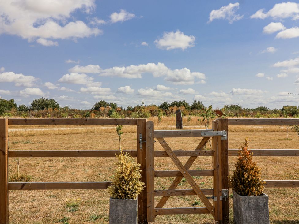 A wooden gate with planters and a grassy area at The Little Loft in Burford