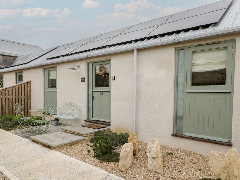 An outdoor area with a door and table at The Little Loft in Burford
