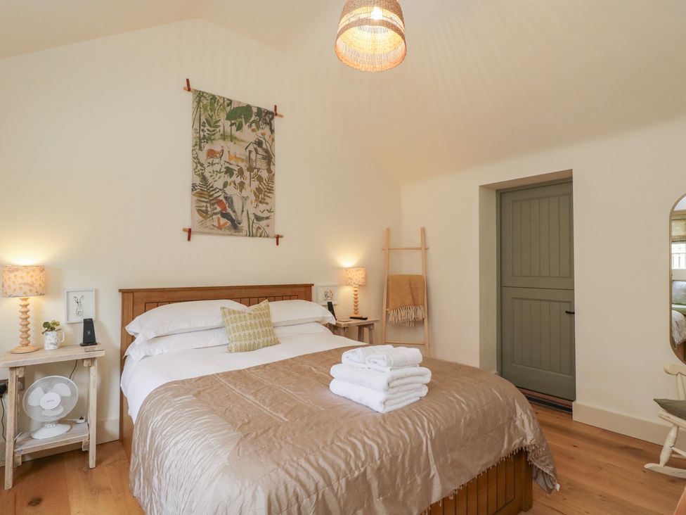 A bedroom with a bed and decorative items at The Little Loft in Burford