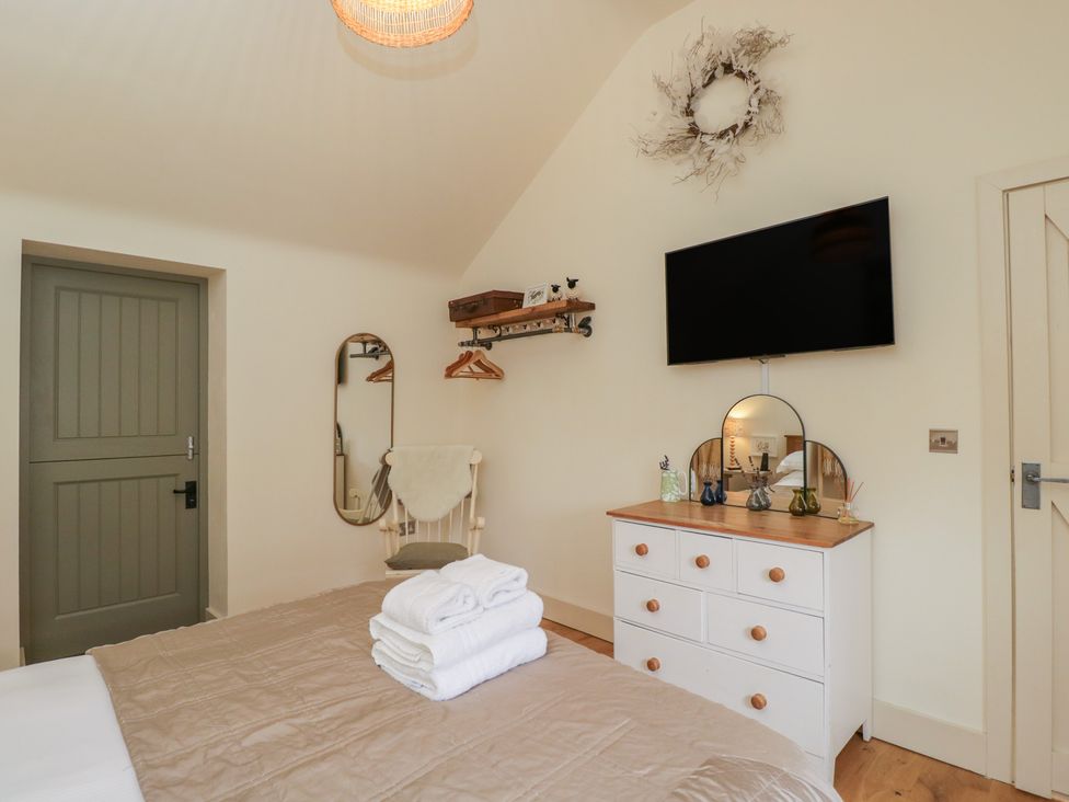 A bedroom with a bed and a television at The Little Loft in Burford