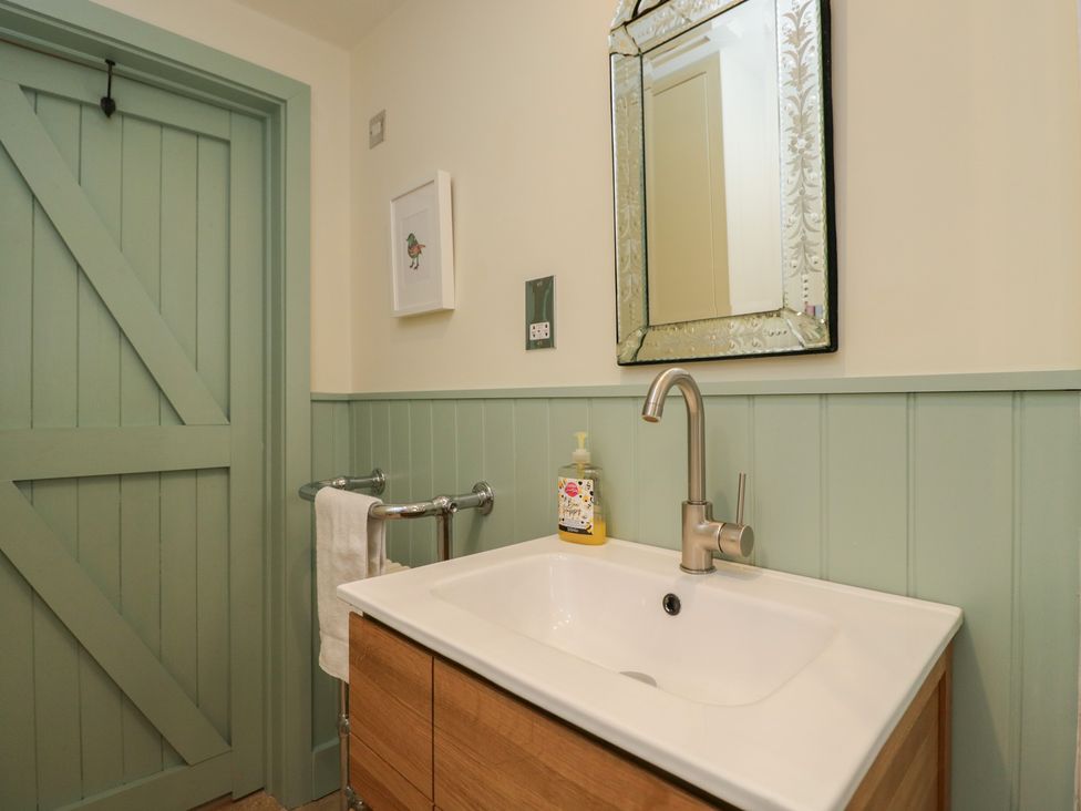 A bathroom with a sink and mirror at The Little Loft in Burford
