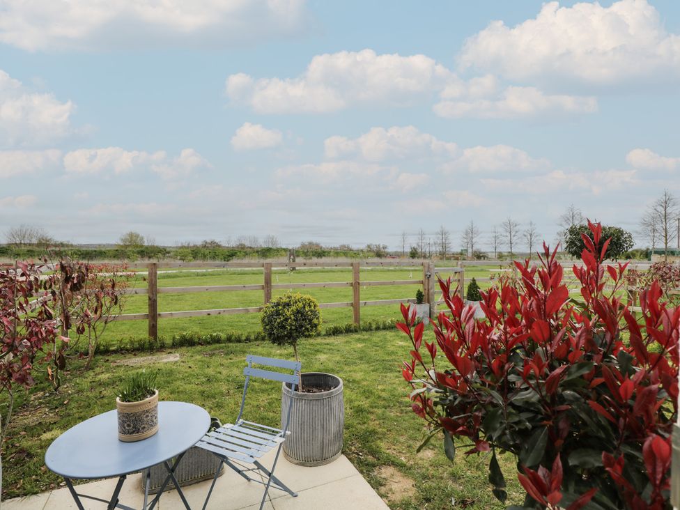 A garden with a table and chair at The Little Loft in Burford