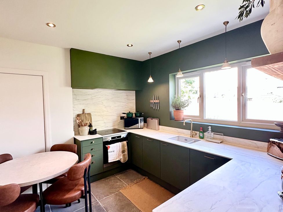 A kitchen with a table and chairs at The Shingles in Sandown