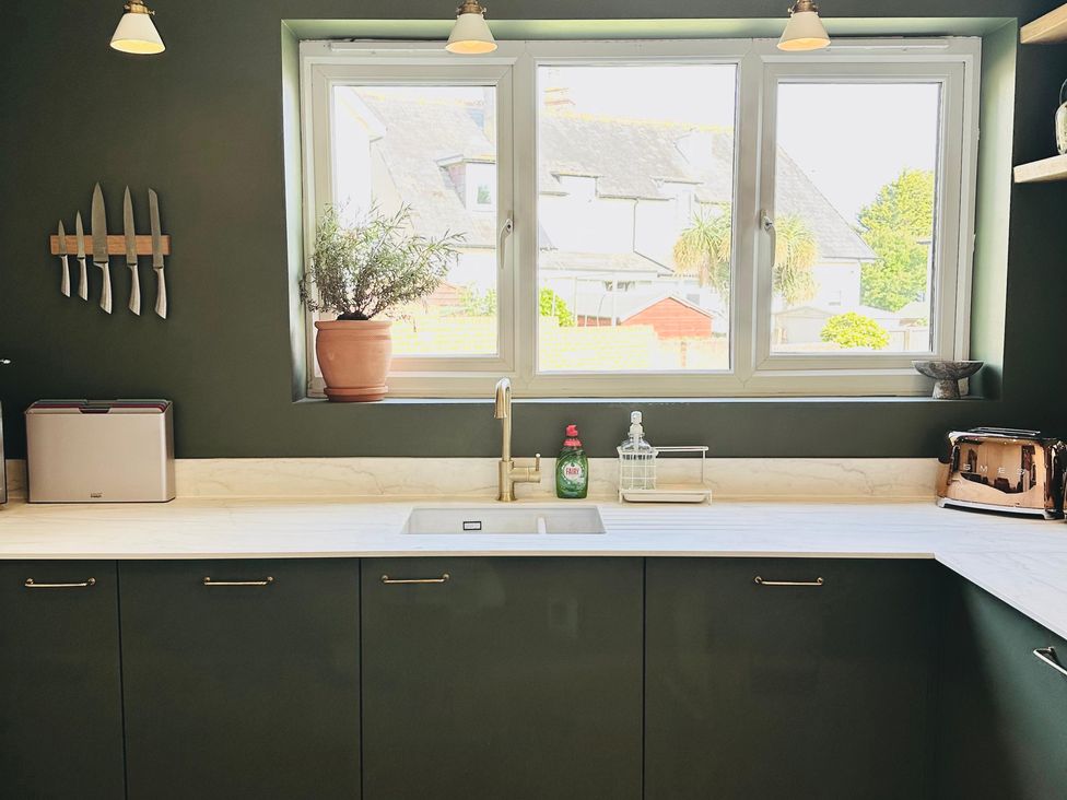A kitchen with a window, sink, and countertop at The Shingles in Sandown