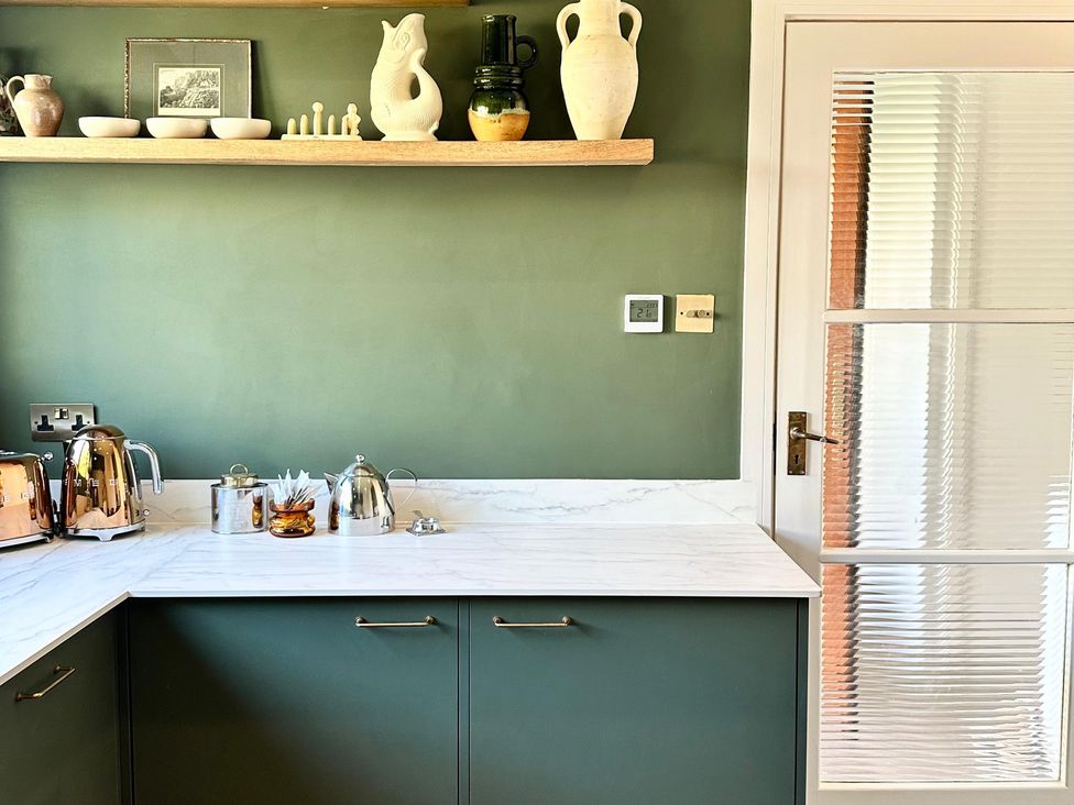 A kitchen with a kettle and teapot on the counter at The Shingles in Sandown