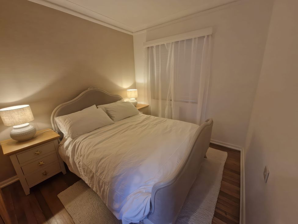 A bedroom with a bed and nightstand at The Shingles in Sandown