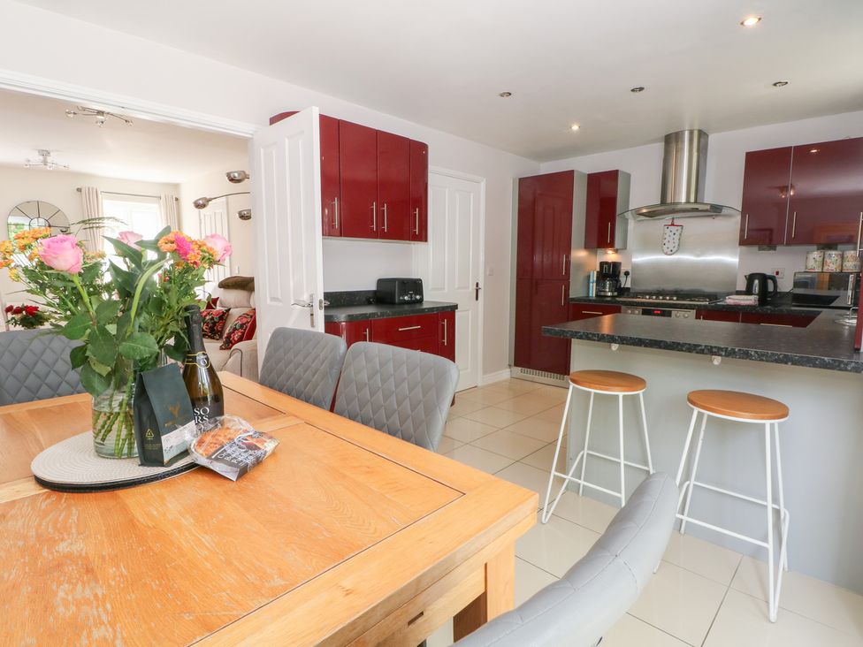 A kitchen with a dining table and flower vase at Woodland View in Buxton