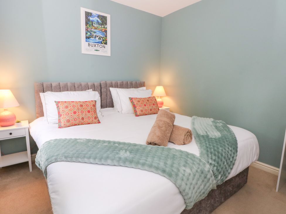 A bedroom with a large bed and lamps at Woodland View in Buxton