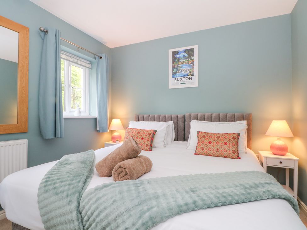 A bedroom with a bed and decorative pillows at Woodland View in Buxton