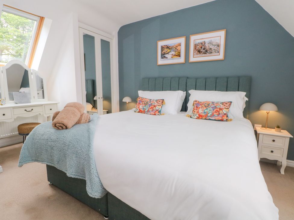 A bedroom with a king-size bed and dressing table at Woodland View Buxton