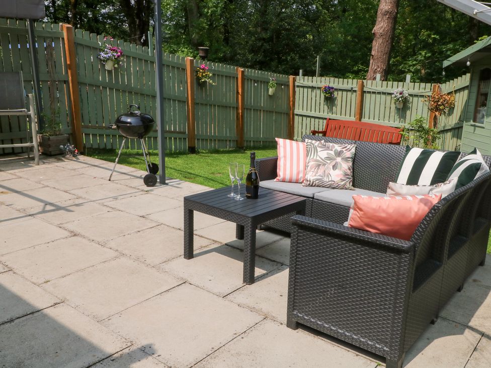 A garden with a seating area and barbecue at Woodland View in Buxton