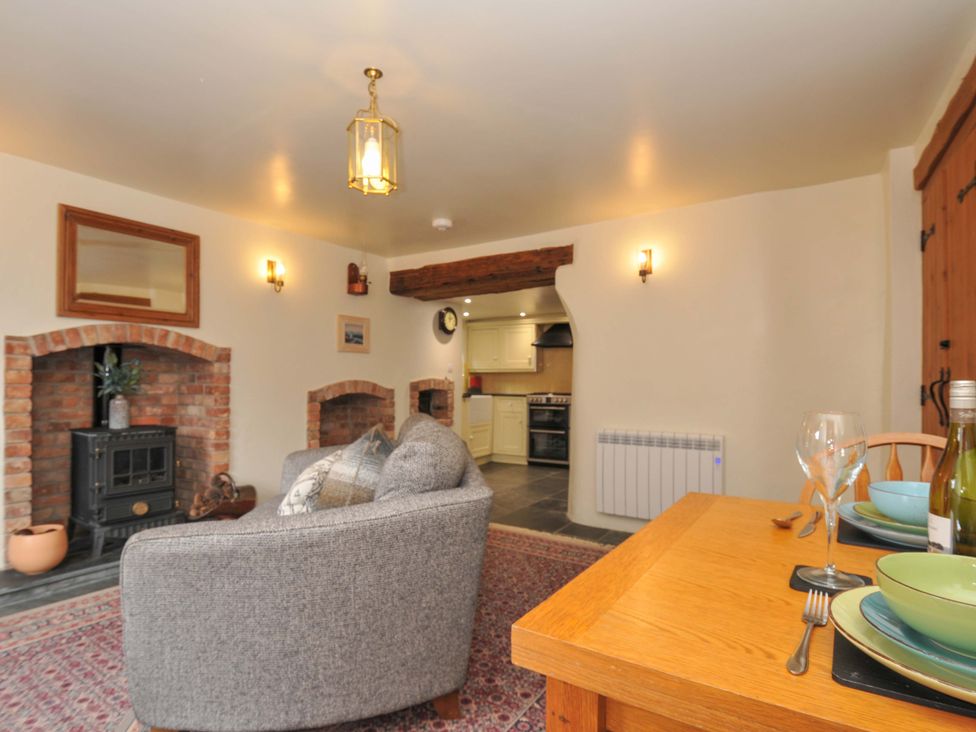 A living room with a sofa and dining table at Jolly Crabber in Porthpean near St Austell