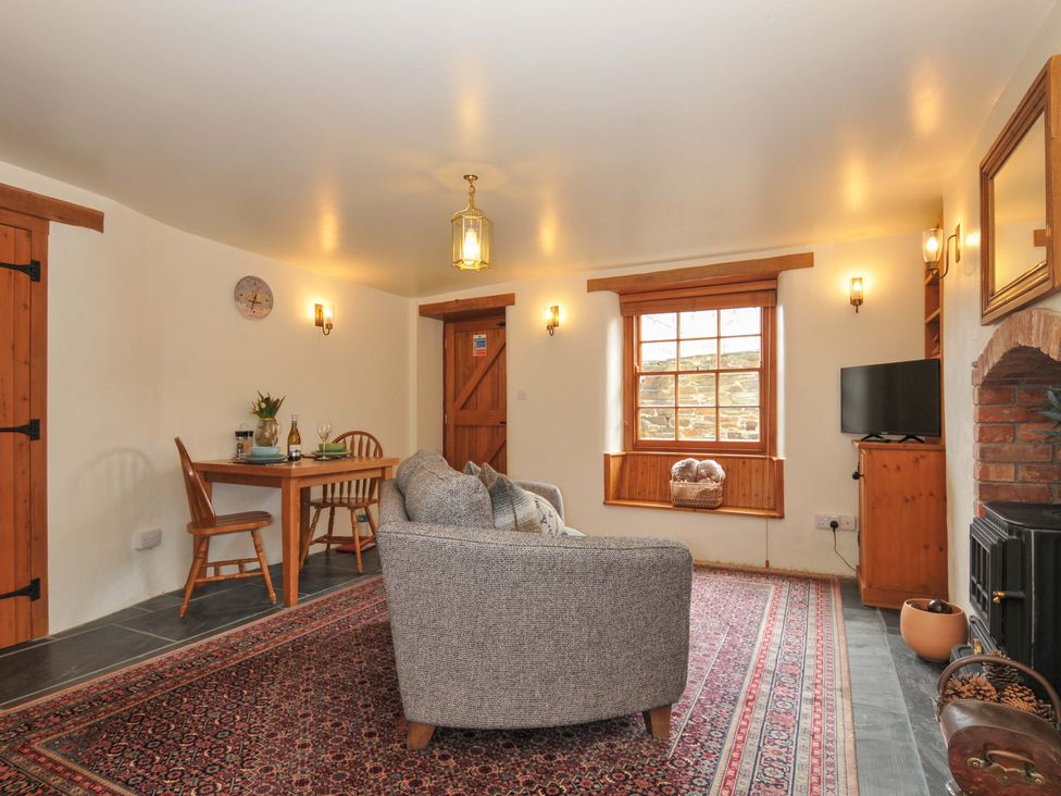 A living room with a sofa and table at Jolly Crabber in Porthpean near St Austell