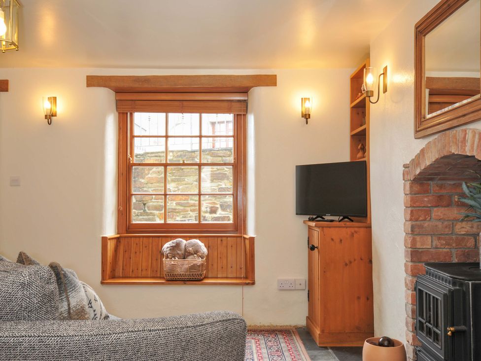 A living room with a window and a TV at Jolly Crabber in Porthpean near St Austell
