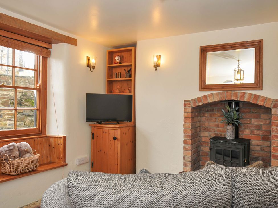 A living room with a television and fireplace at Jolly Crabber in Porthpean near St Austell