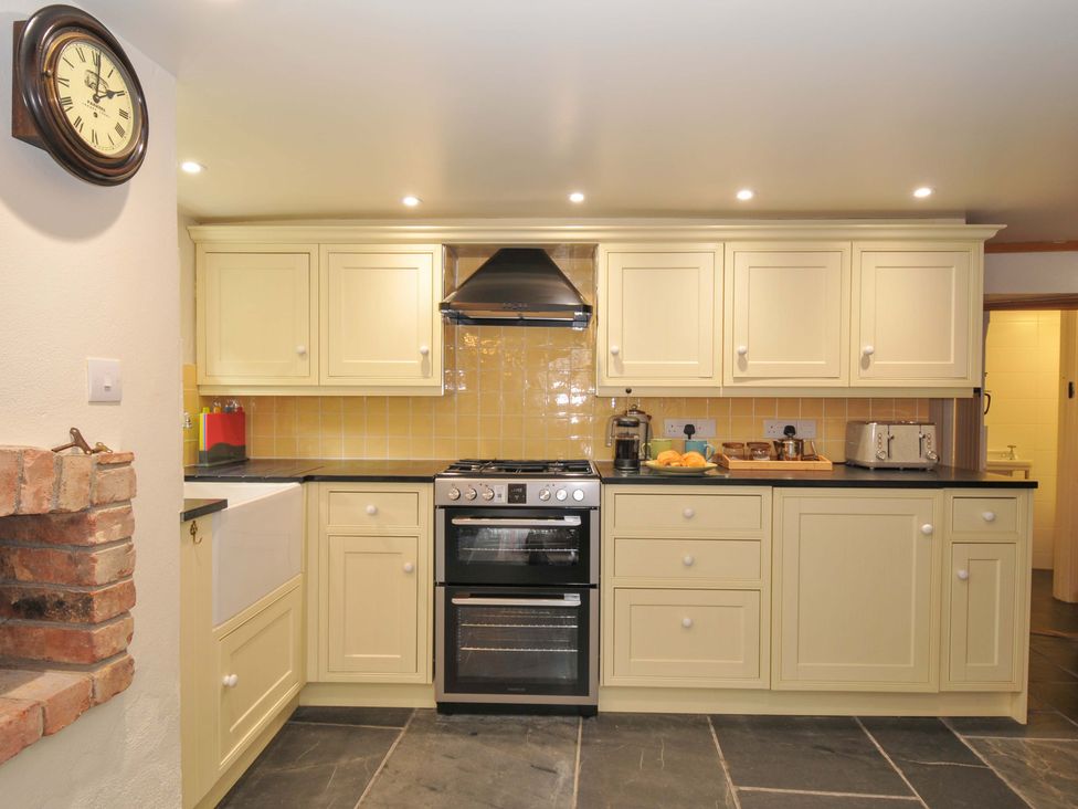 A kitchen with cabinets and a cooking range at Jolly Crabber in Porthpean near St Austell