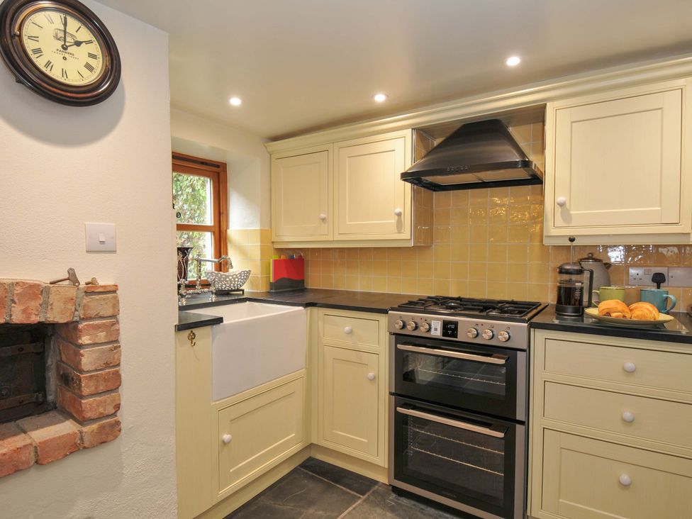 A kitchen with a gas stove and a sink at Jolly Crabber in Porthpean near St Austell
